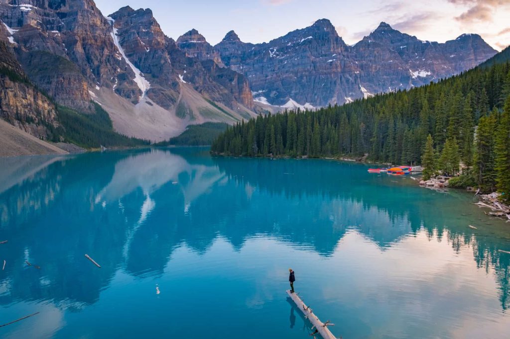 Cameron standing on the log on Moraine Lake at sunset