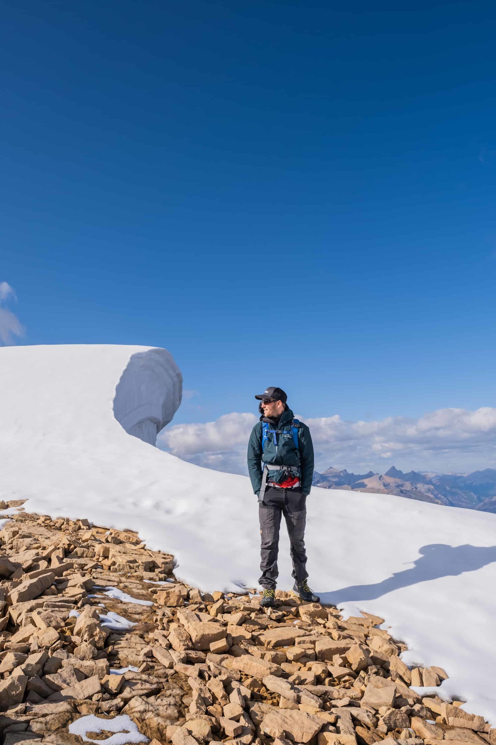 Cameron stands by a large cornice on Observation Peak