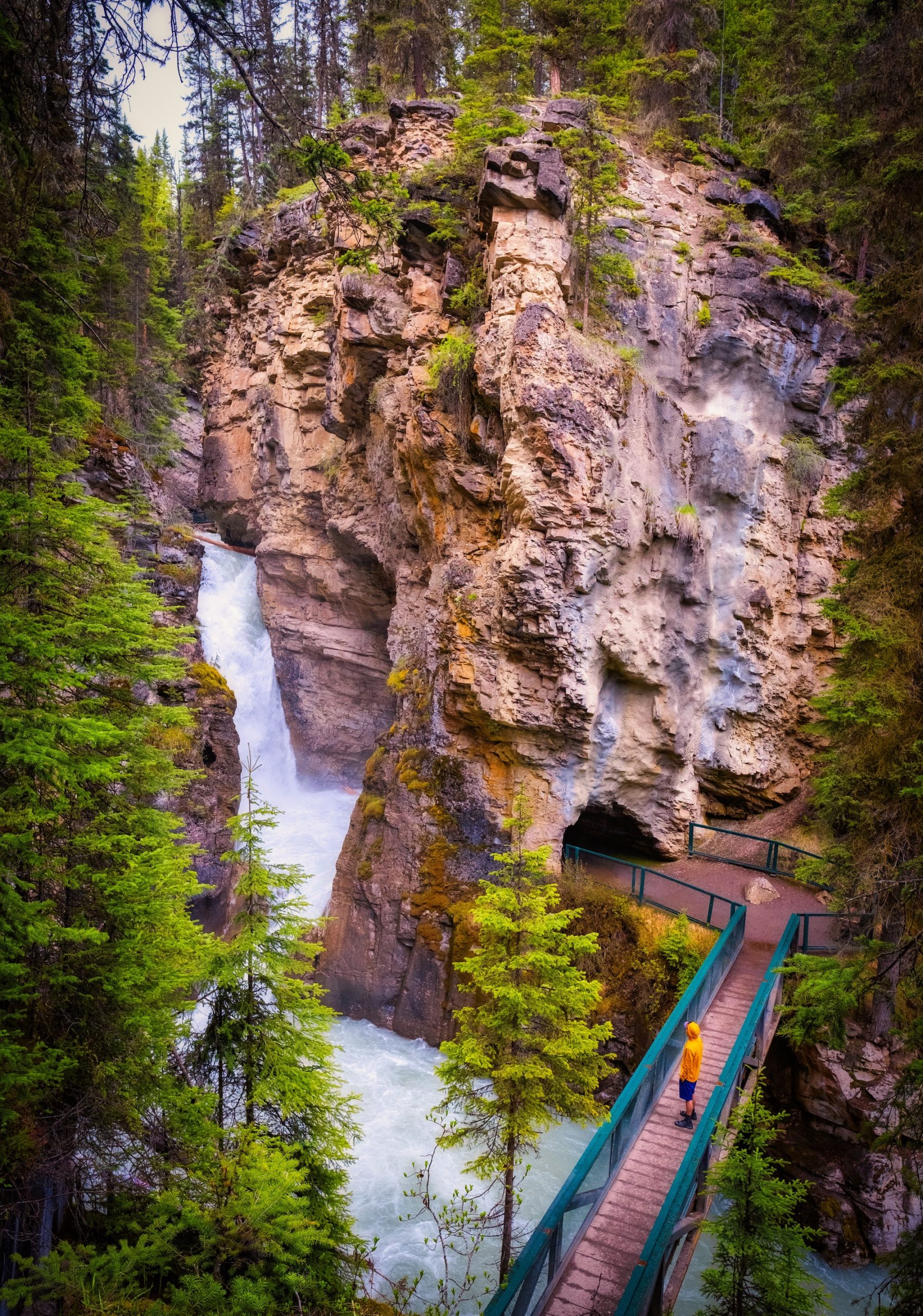 Cameron Stands Alone On A Bridge At The Lower Falls Of Johnston Canyon