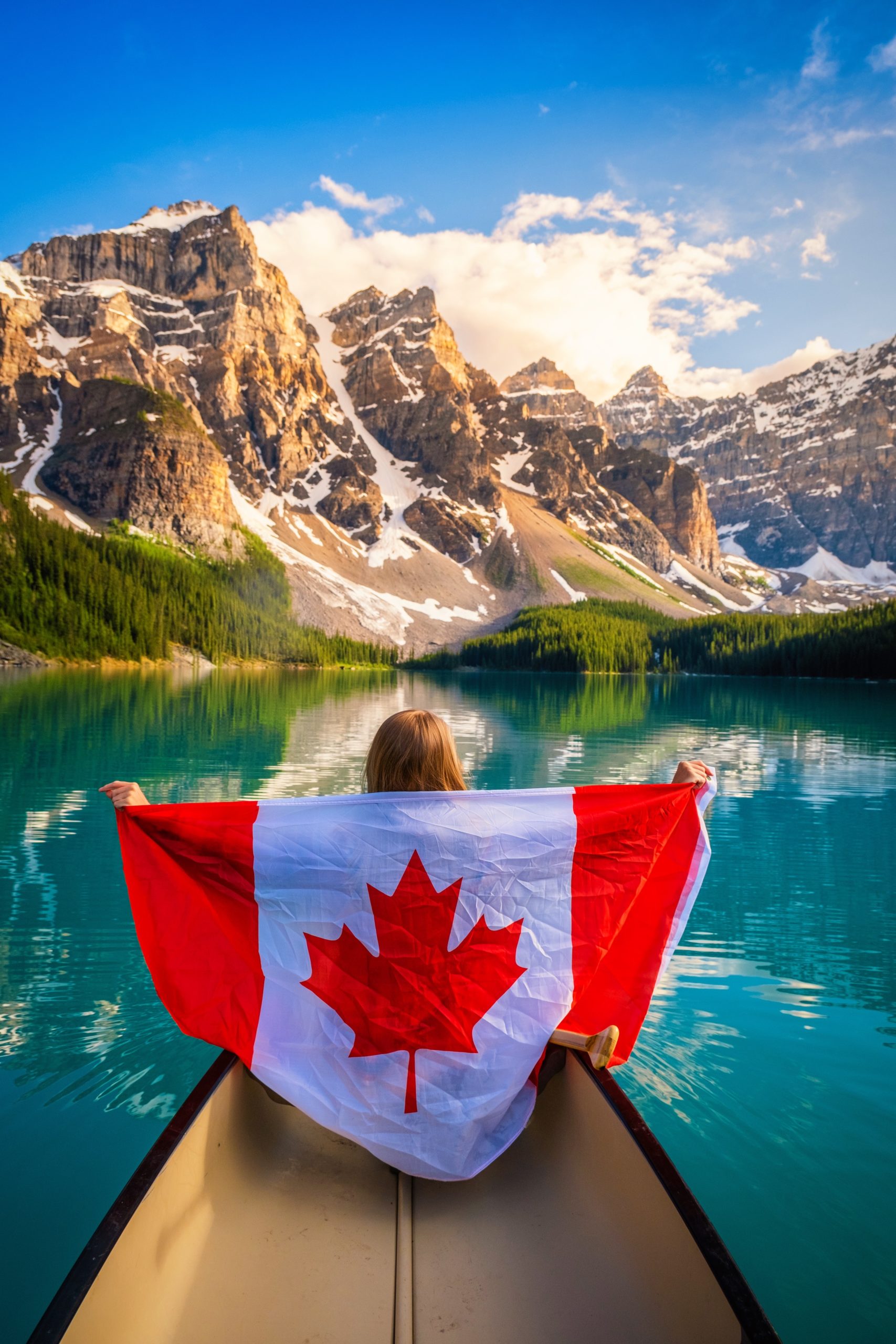 Natasha holds Canadian Flag in canoe on Moraine Lake