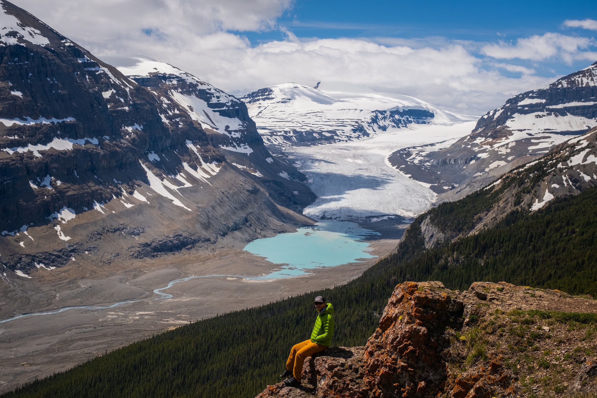 Cameron Sits On A Rock And Looks Out To Glacier From Parker Ridge