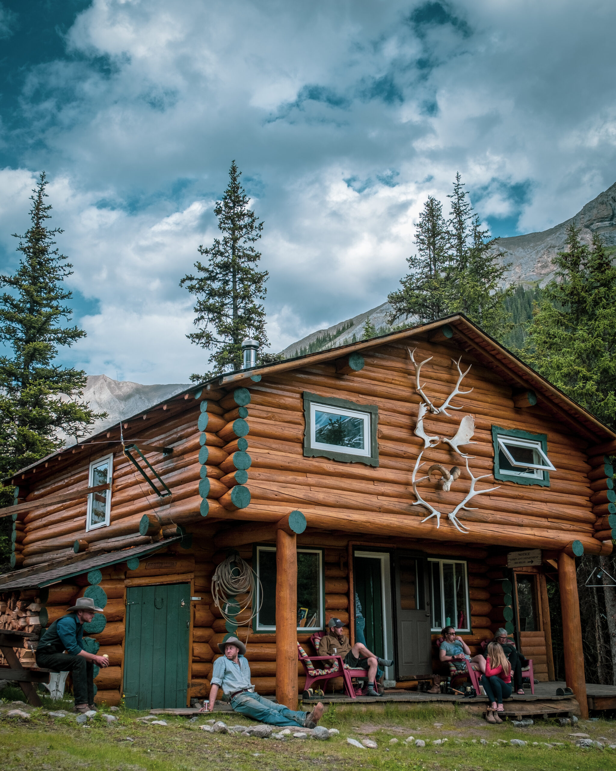 Group Relaxing Outside The Halfway Lodge In Banff