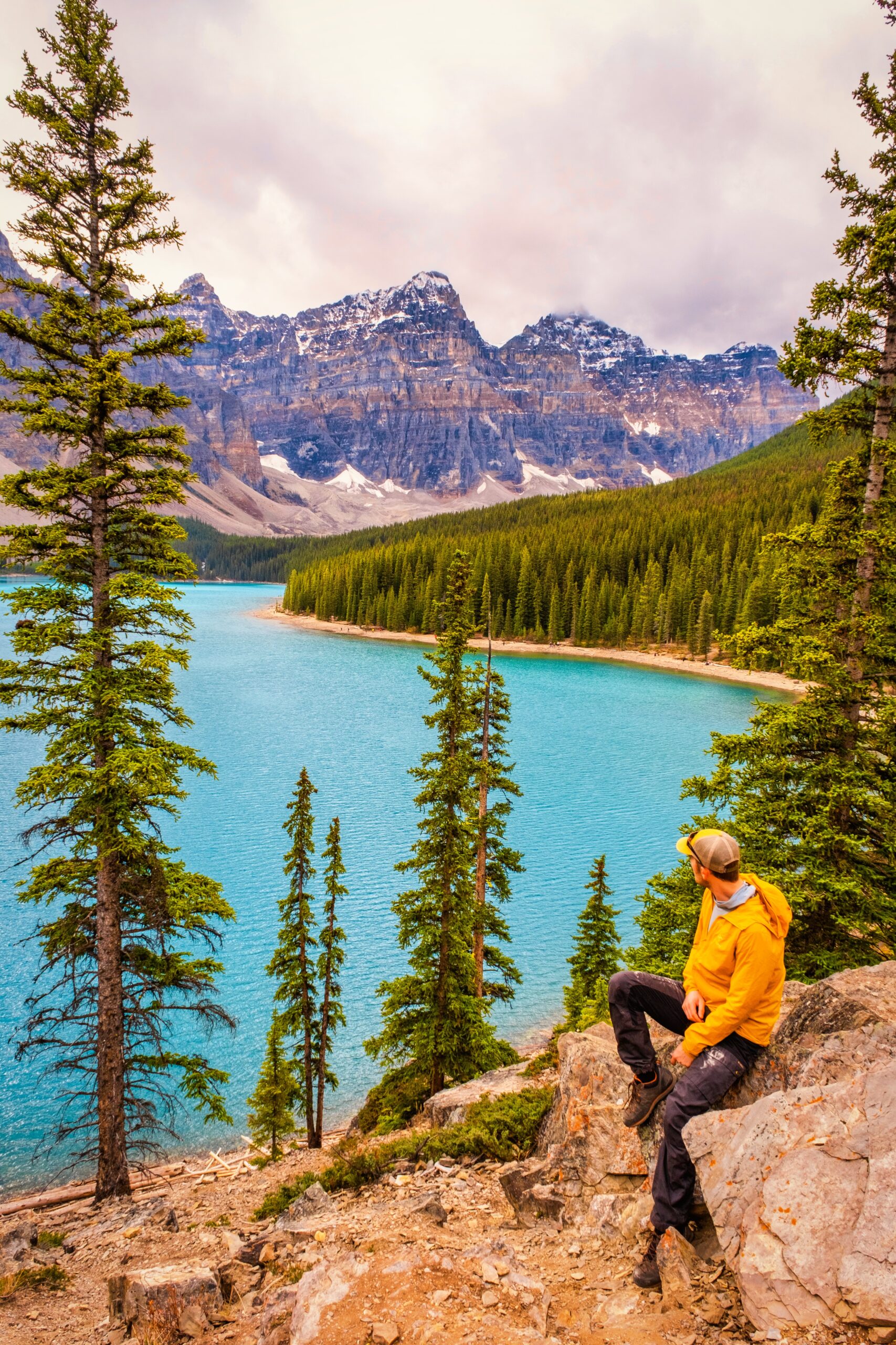 Cameron sits on the Rock Pile Trail as rain rolls over the Ten Peaks