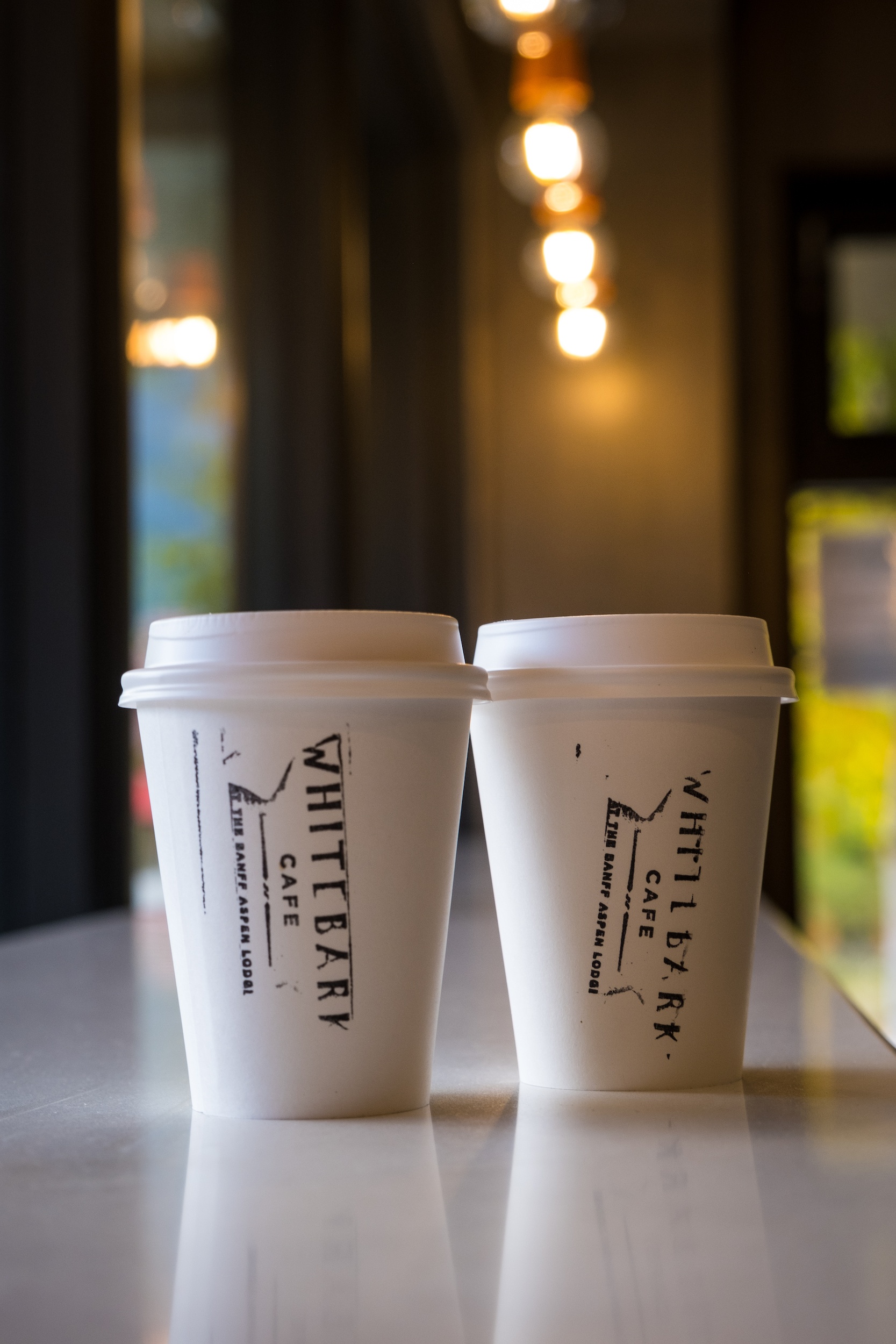 Two coffee cups sitting on the countertop at the Whitebark Cafe