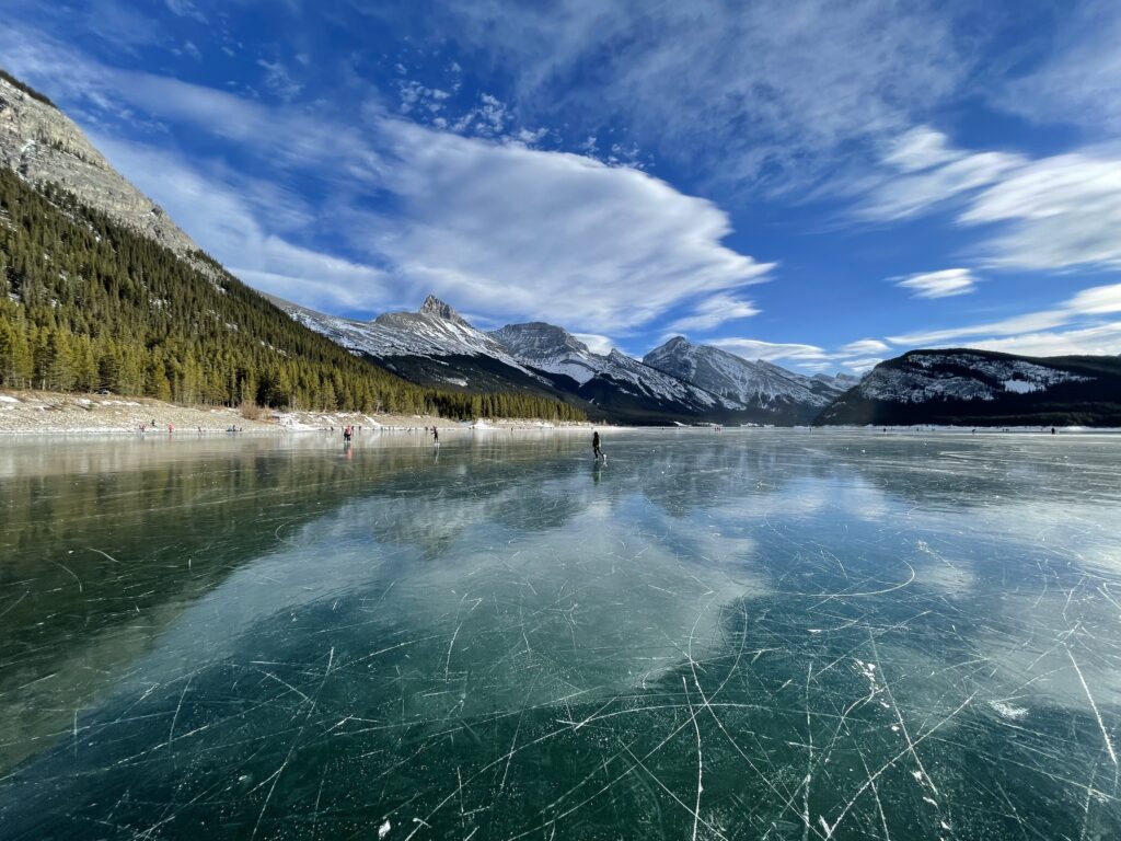 Ice Skaters on the Spray Lakes Reservoir on a sunny day