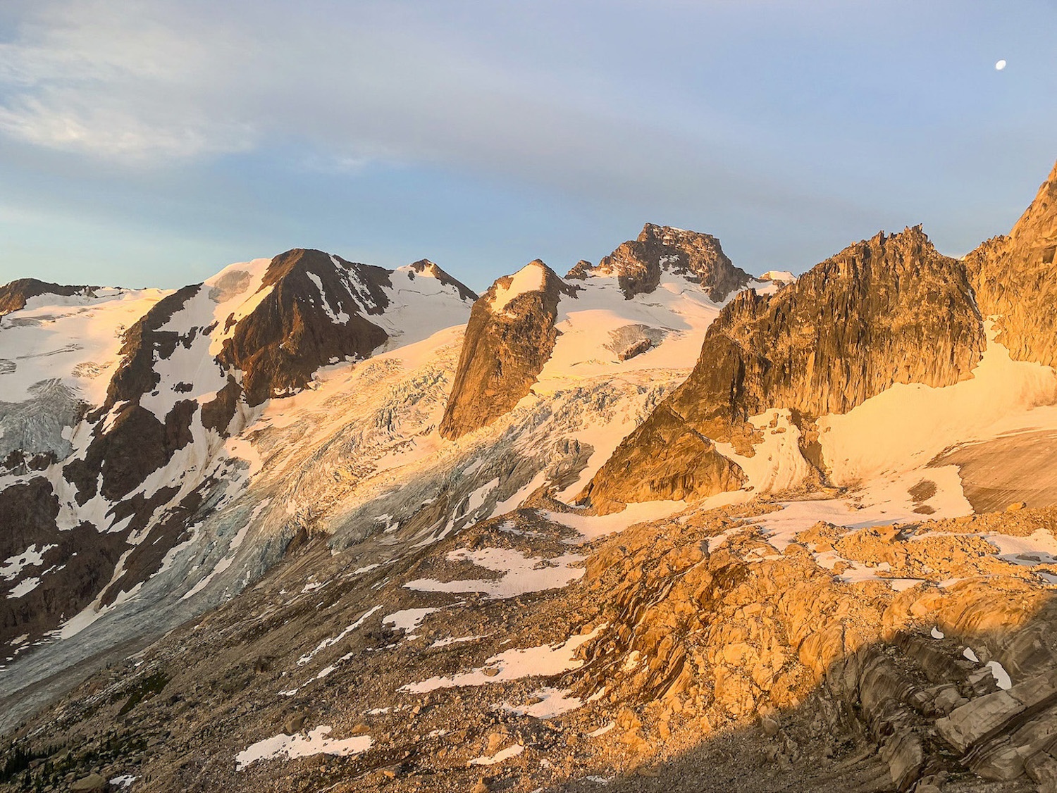 the Bugaboo glacier at dusk, with the moon in the sky above it