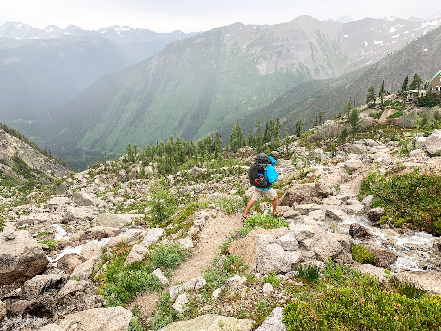 Crossing a glacial stream on the hike down with the Kain Hut in the distance