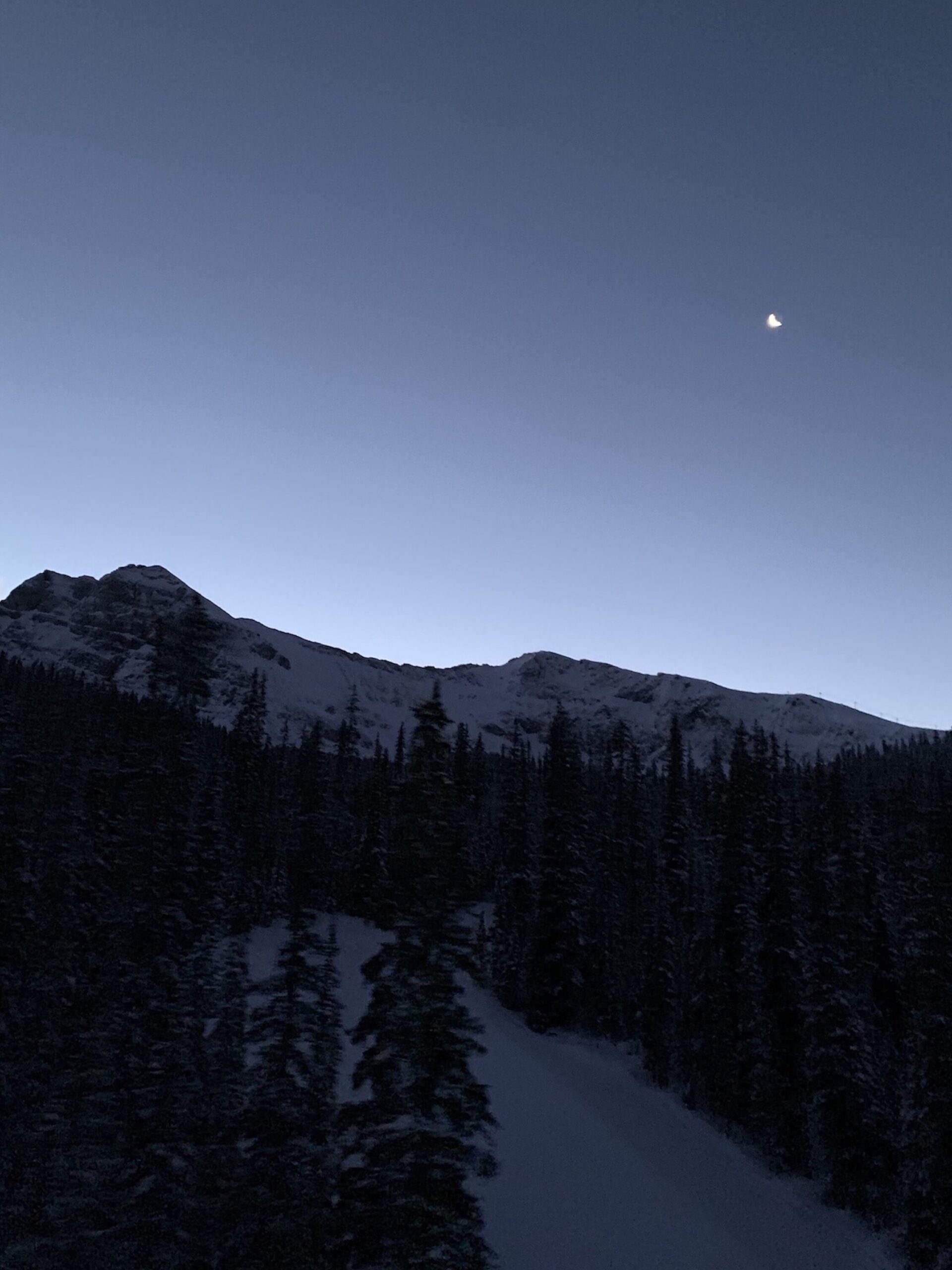 The view of the Delirium Dive at dawn with the moon above the mountains