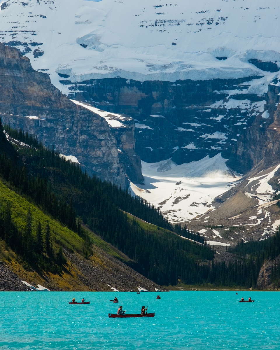 Canoes On Lake Louise With Mount Victoria In The Background