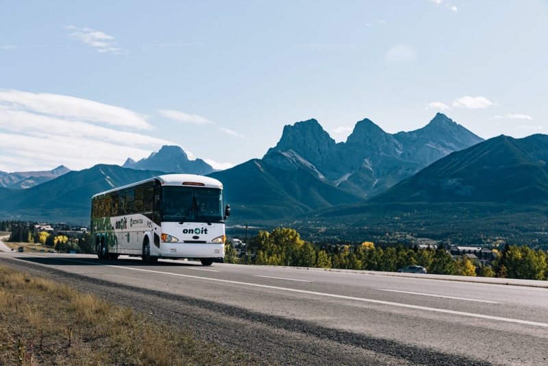 On-It Regional Transit bus driving on the highway through Canmore