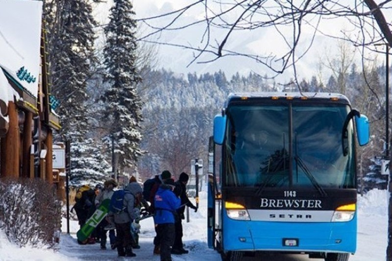 Skiers and snowboarders boarding a shuttle bus in Banff