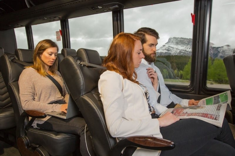 People riding on the airport shuttle to Banff National Park